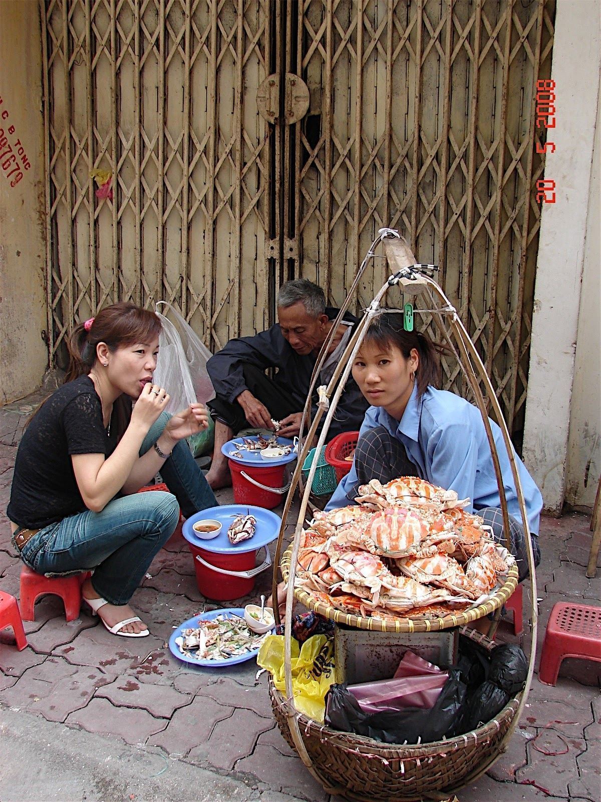 A street food vendor preparing seafood dishes in Hanoi