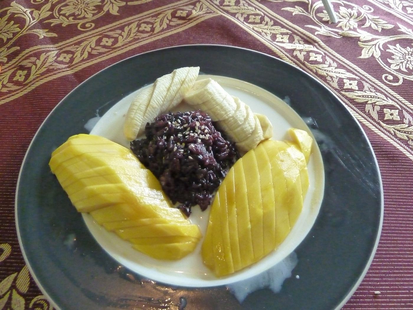 A plate of mango sticky rice with coconut cream