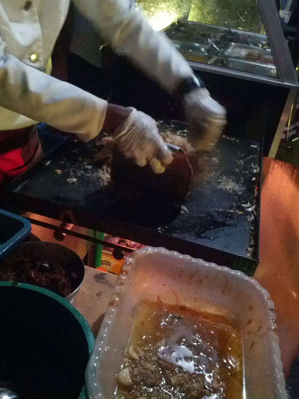 Kottu roti being chopped and stir-fried on a hot griddle