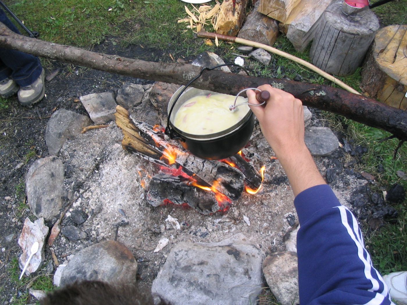 A pot of cheese fondue being kept warm over a flame