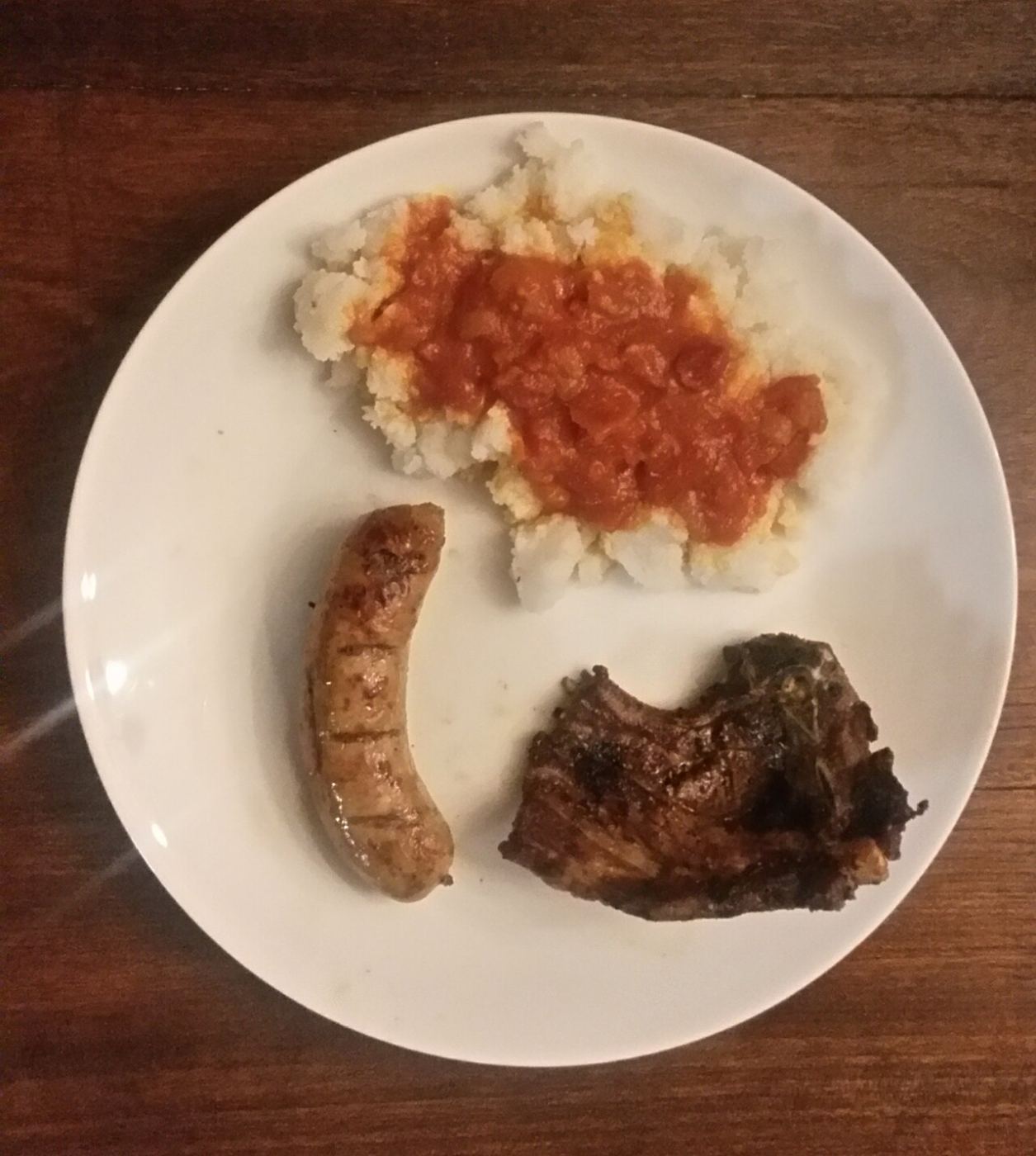 Pap served with wors and a grilled chop, a classic South African plate