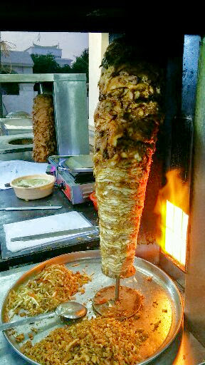 Shawarma meat roasting on a vertical rotisserie spit