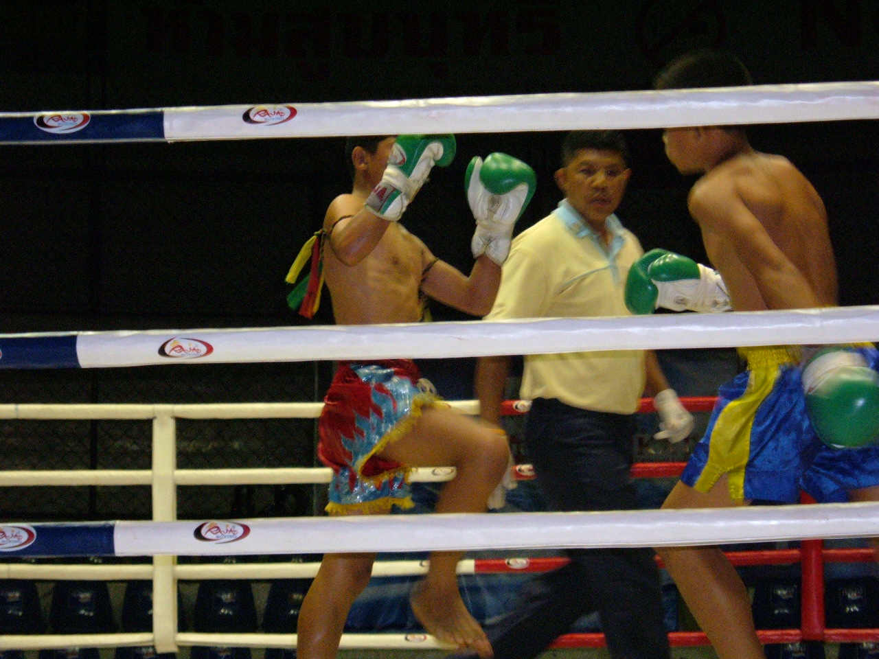 Two Muay Thai fighters competing in the ring at Rajadamnern Stadium, Bangkok