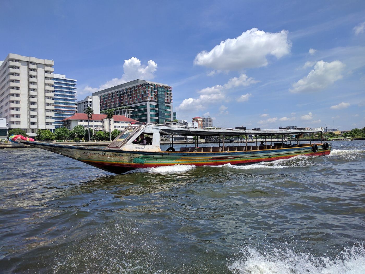 A traditional long-tail boat crossing the Chao Phraya River in Bangkok