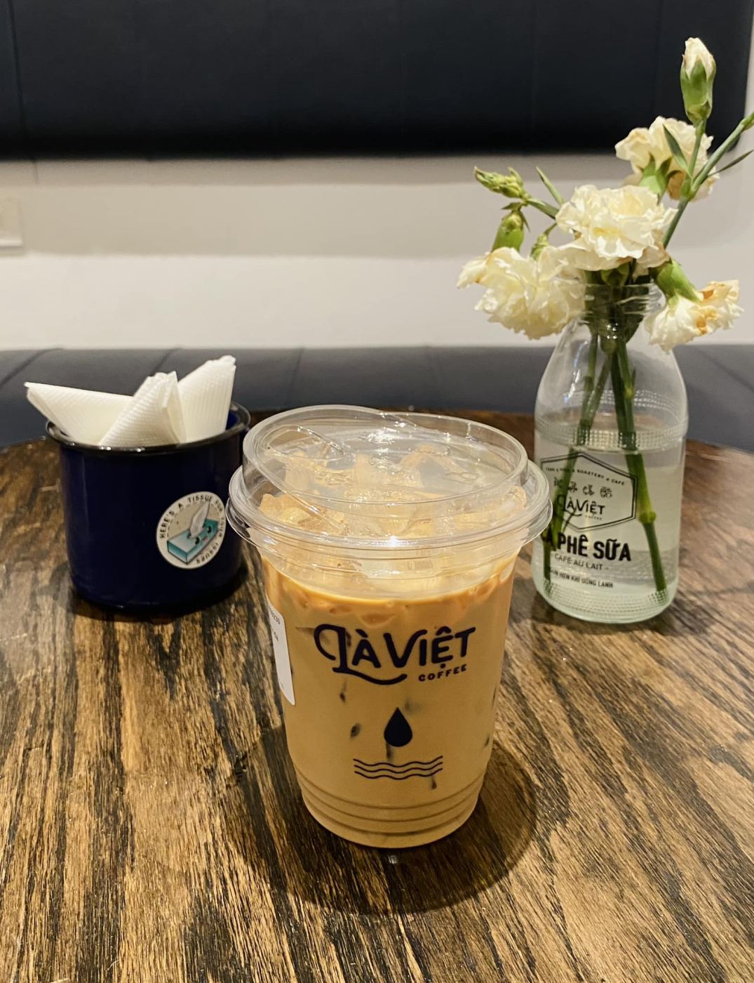 A cup of Vietnamese iced coffee with condensed milk on a wooden table