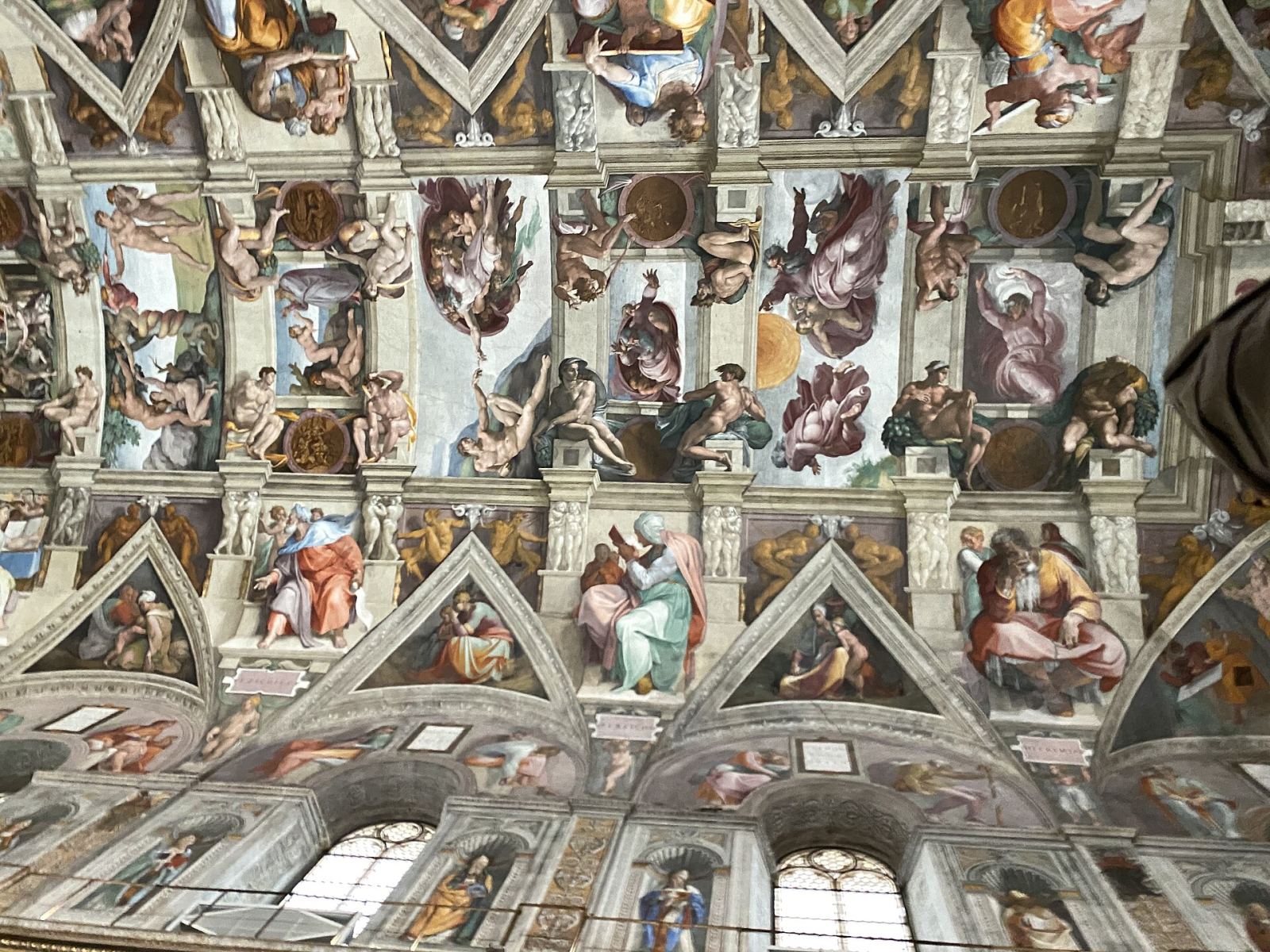 Michelangelo's frescoed ceiling inside the Sistine Chapel, showing panels including the Creation scenes