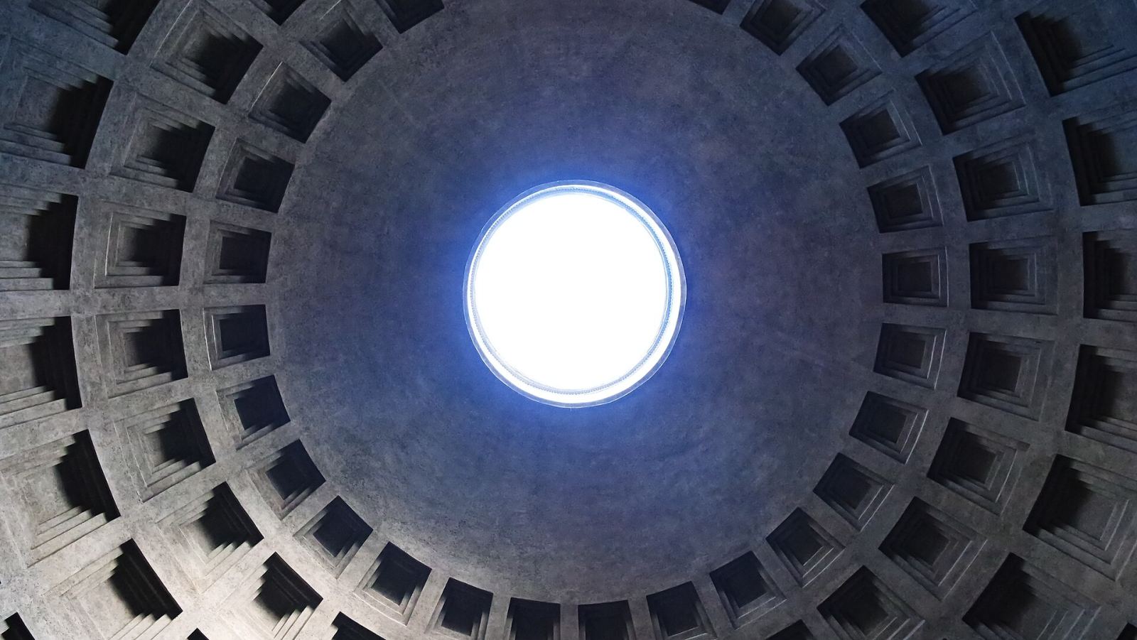 Looking straight up at the Pantheon's coffered concrete dome and its central oculus letting in daylight