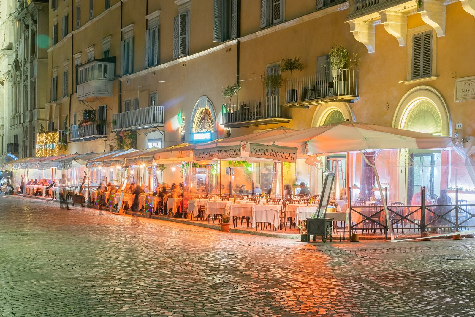 Piazza Navona street sign and restaurant row in Rome at night