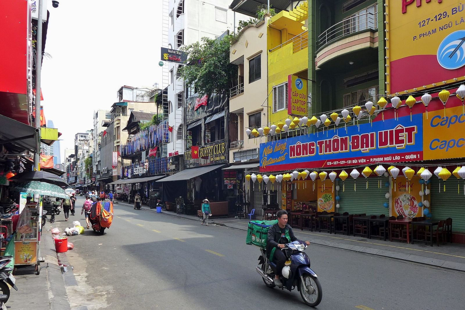 Daytime view of Bui Vien Street in Ho Chi Minh City with shops and motorbikes