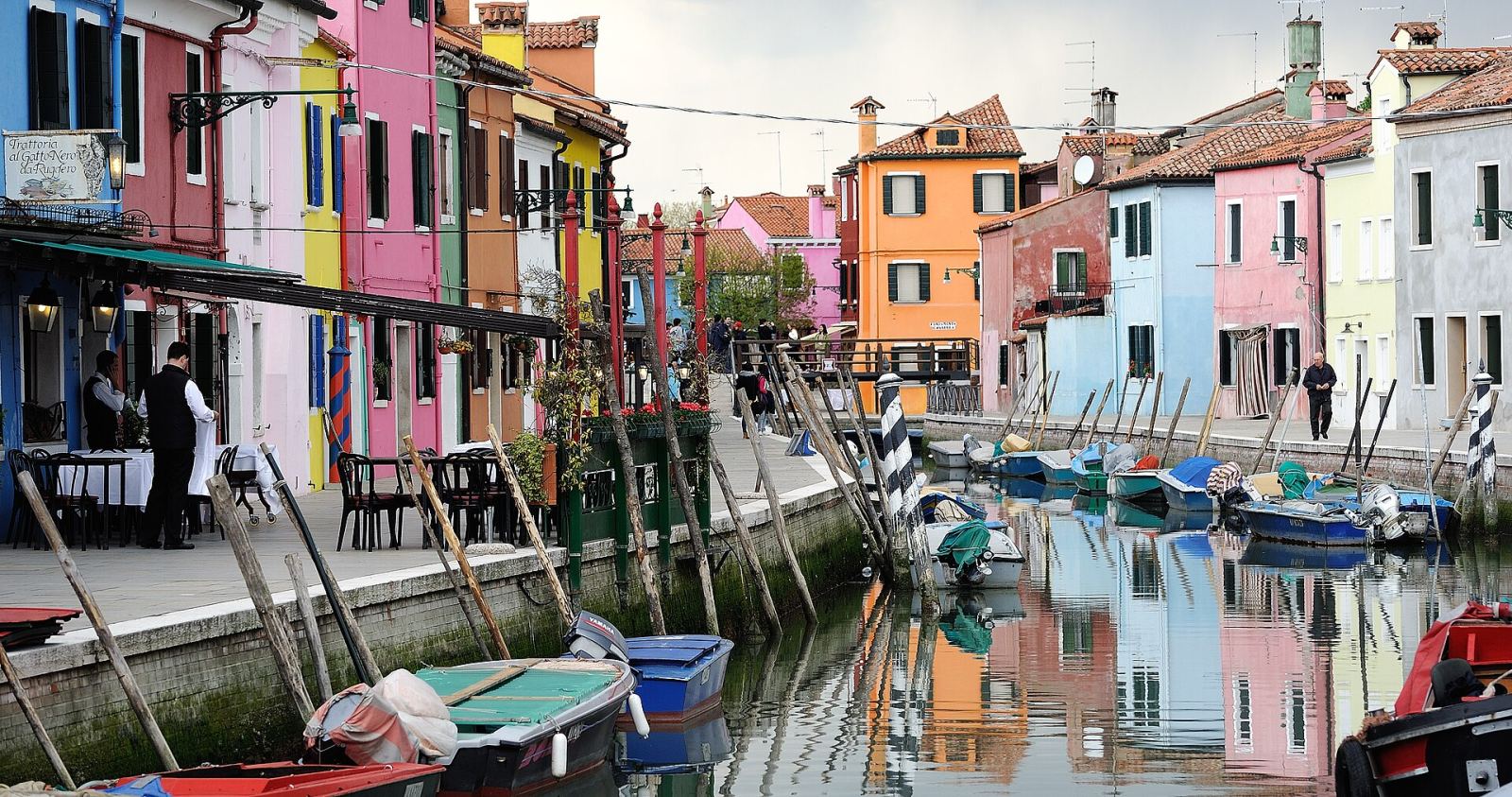 Canal in Burano lined with colorful houses and boats